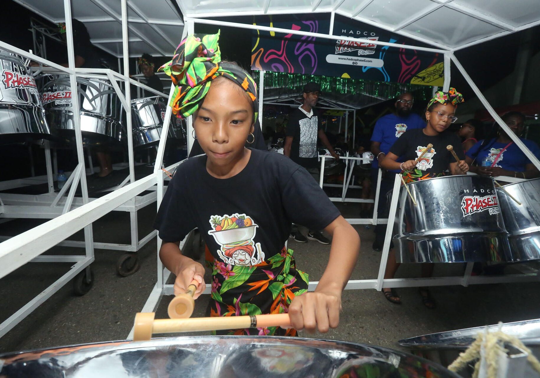 Young musician playing steel drum wearing headwrap