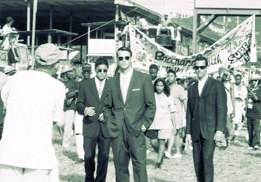 Three men in suits walking in parade